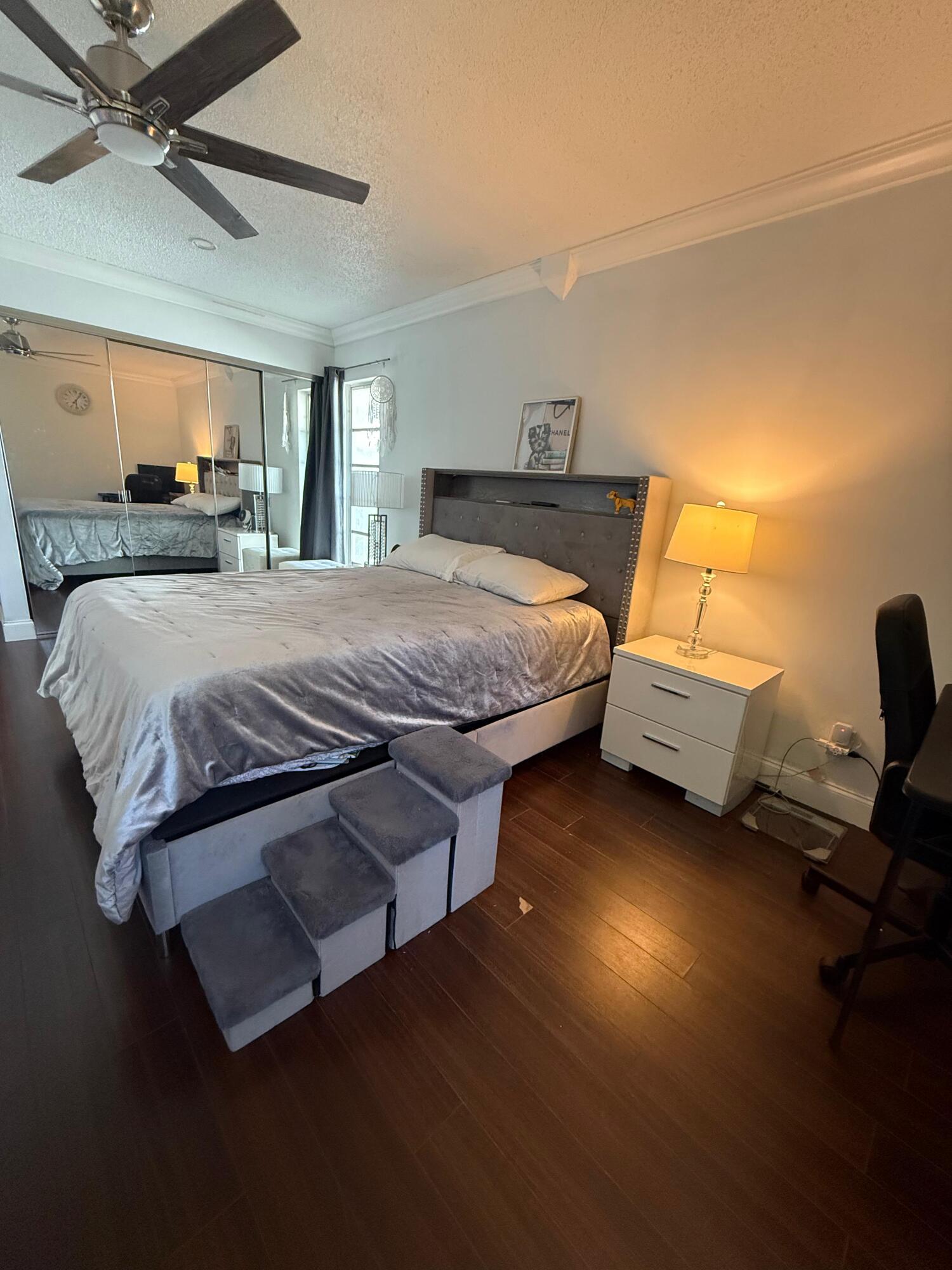 7024 Northwest 63rd Street Tamarac, FL 33321 - Photo 29 of 50 a spacious bedroom with a bed and a chandelier