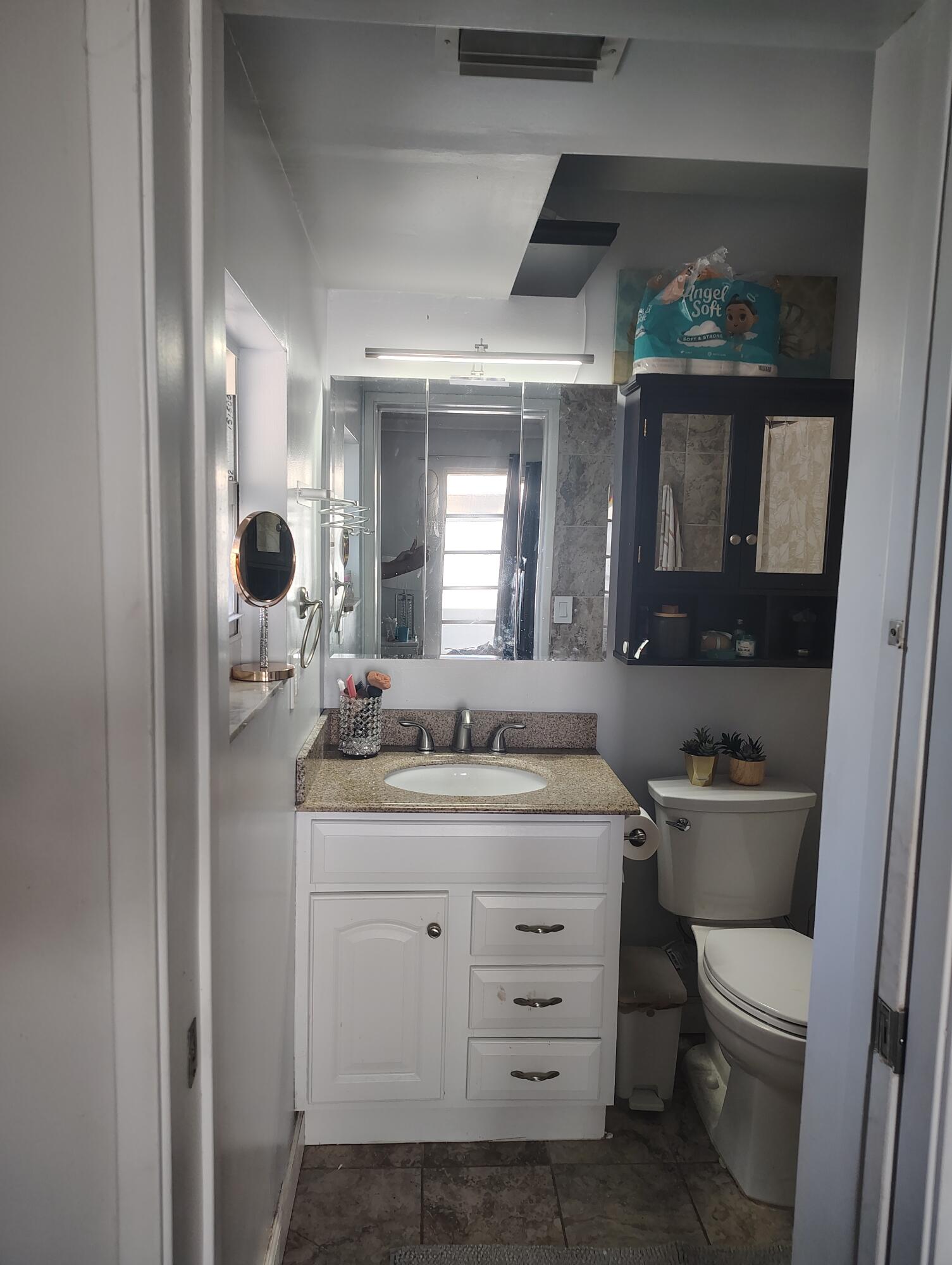7024 Northwest 63rd Street Tamarac, FL 33321 - Photo 33 of 50 a bathroom with a toilet sink and mirror