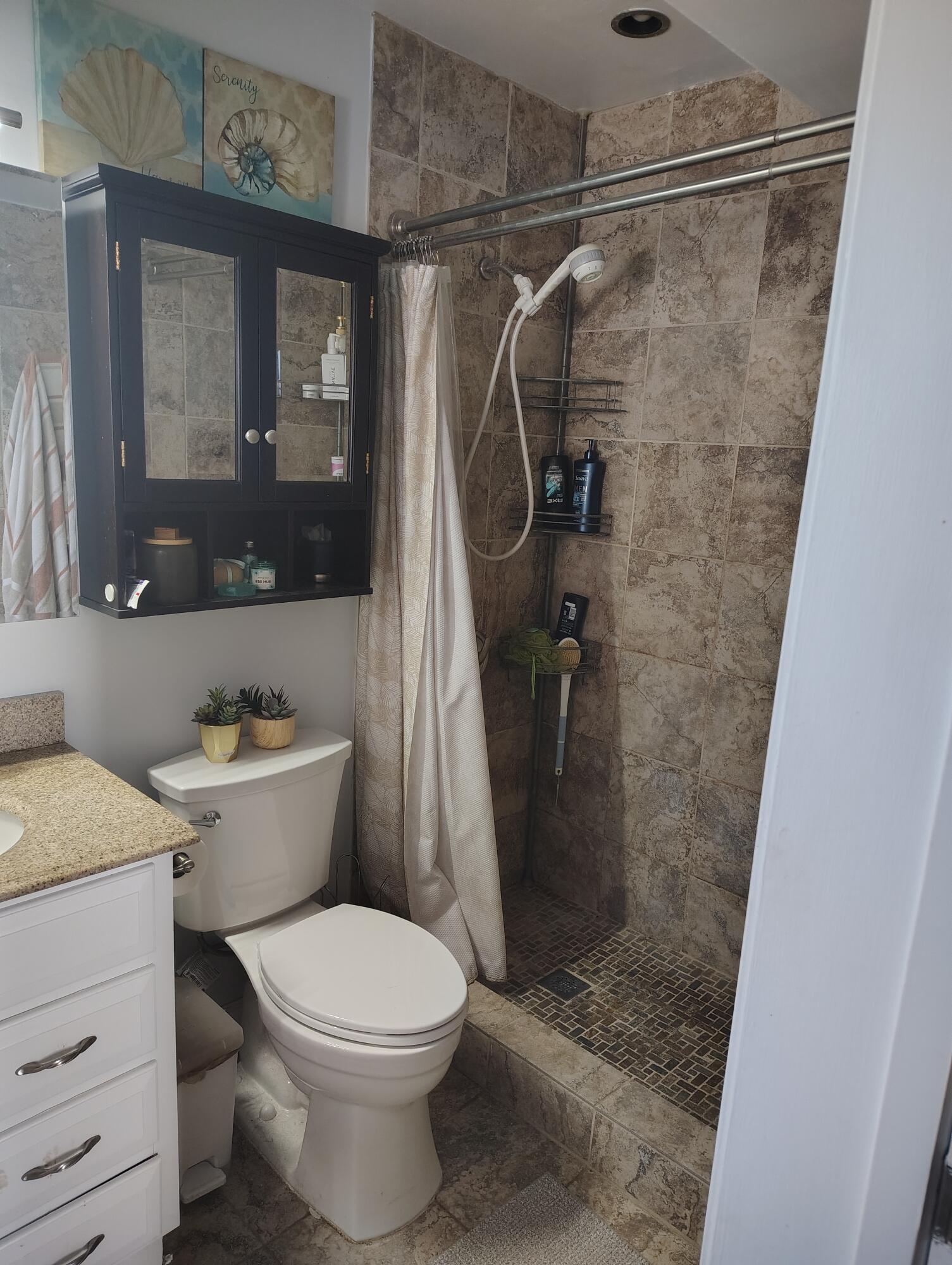 7024 Northwest 63rd Street Tamarac, FL 33321 - Photo 35 of 50 a bathroom with a shower a toilet and a sink
