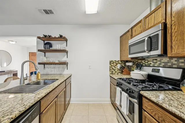 a kitchen with granite countertop a stove and a sink