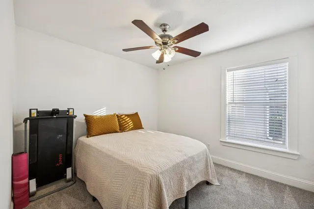 a bedroom with a bed and a ceiling fan