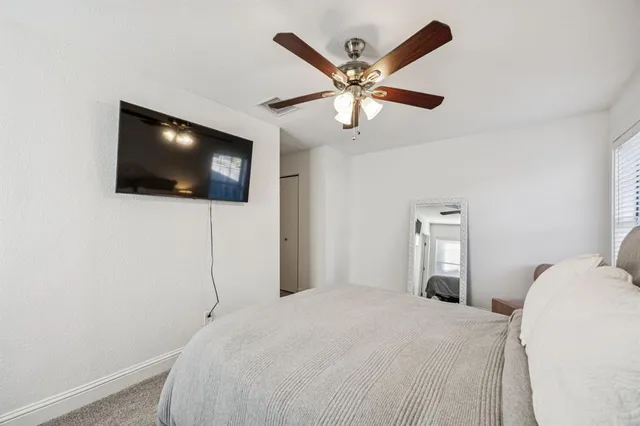 a bedroom with a large bed and a flat screen tv