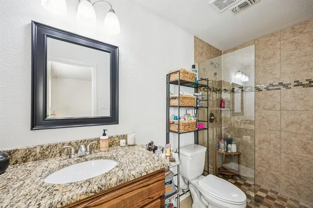 a bathroom with a granite countertop toilet sink and shower