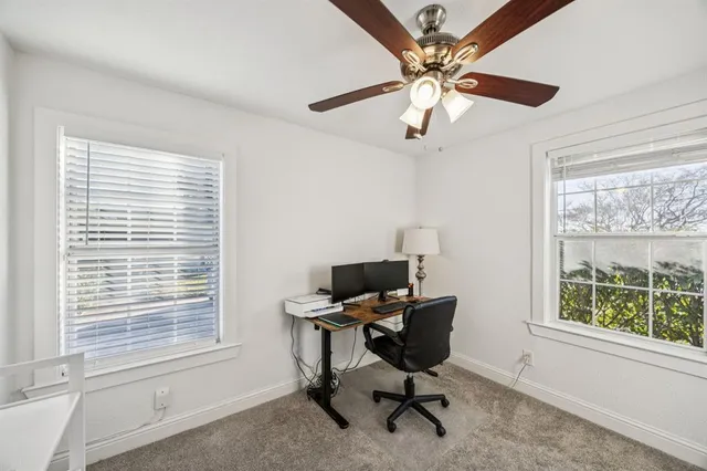 a view of a workspace with furniture and a window