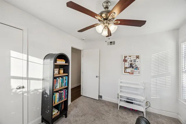 a view of a room with shelves and a chandelier fan