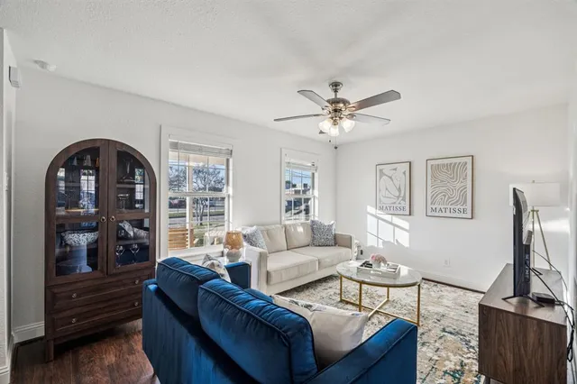 a living room with furniture a flat screen tv and a large window