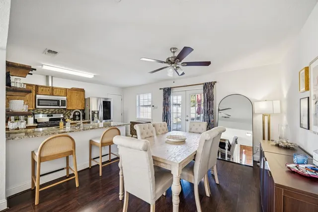 a view of a dining room with furniture a rug and wooden floor