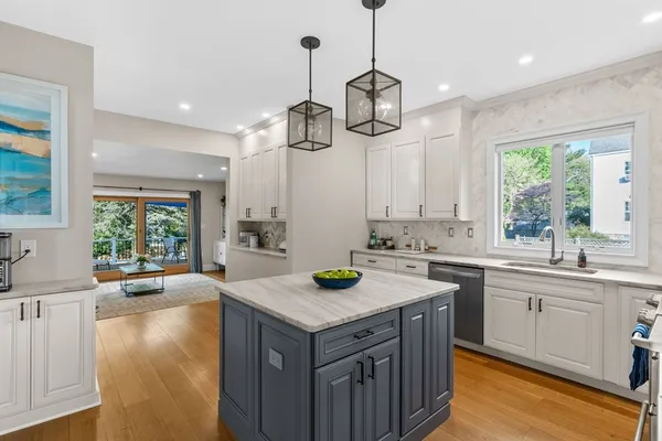 a kitchen with a sink a center island a stove and a window
