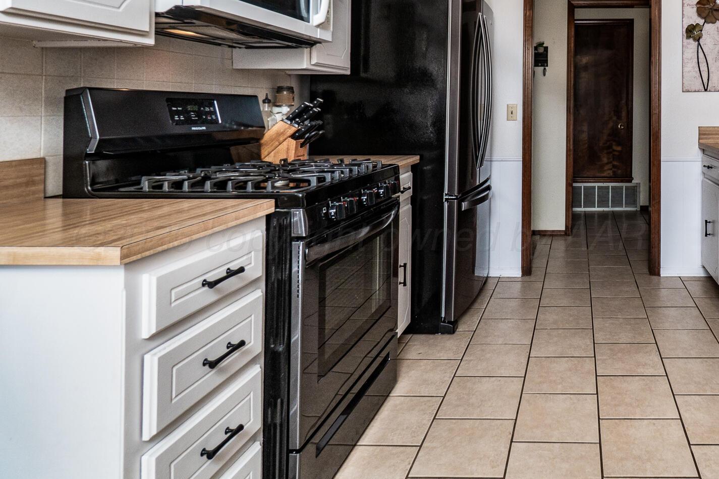 5702 South Milam Street Amarillo, TX 79110 - Photo 13 of 22 a kitchen with a stove and a microwave