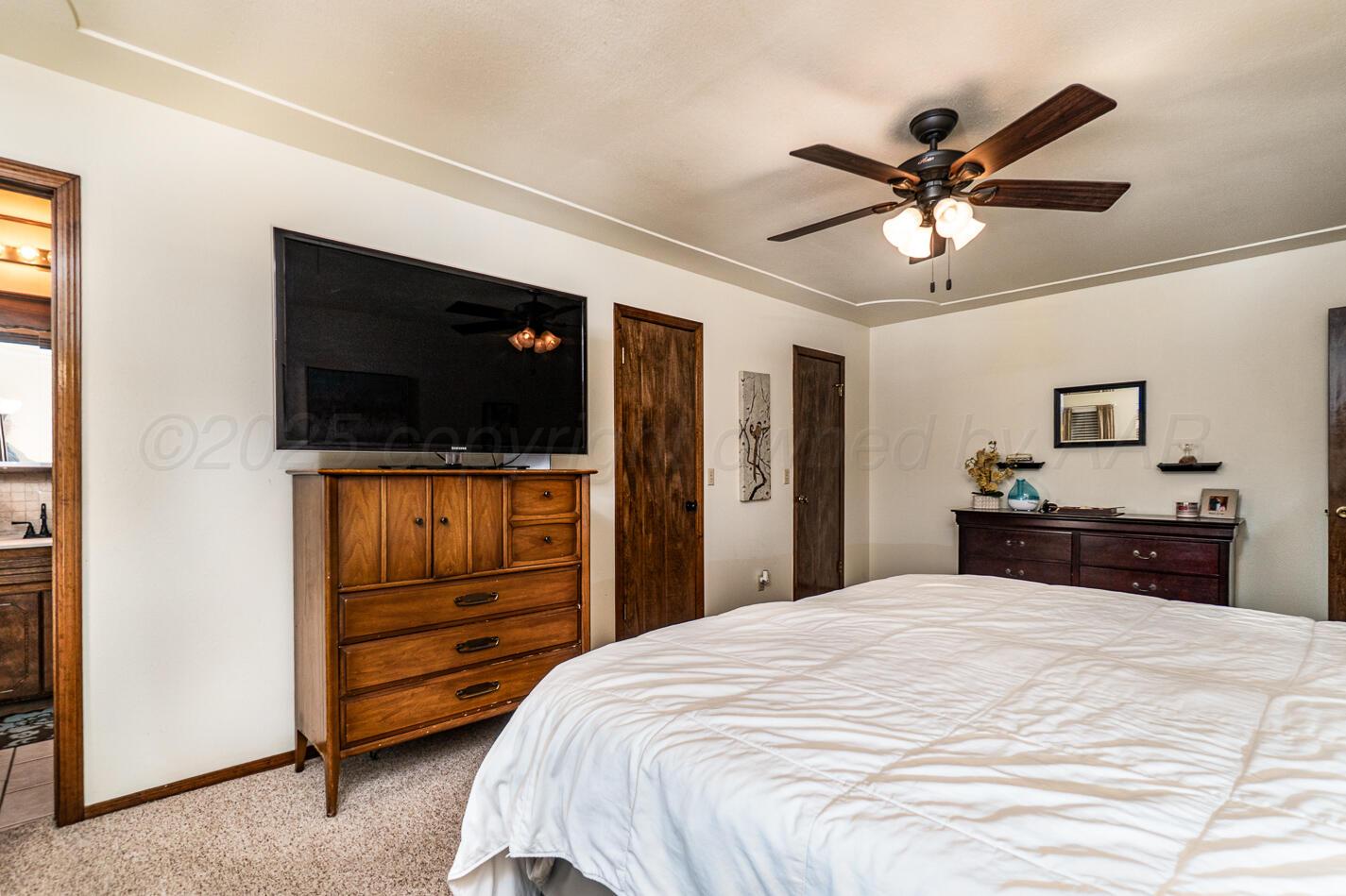 5702 South Milam Street Amarillo, TX 79110 - Photo 14 of 22 a bedroom with a bed and a flat screen tv