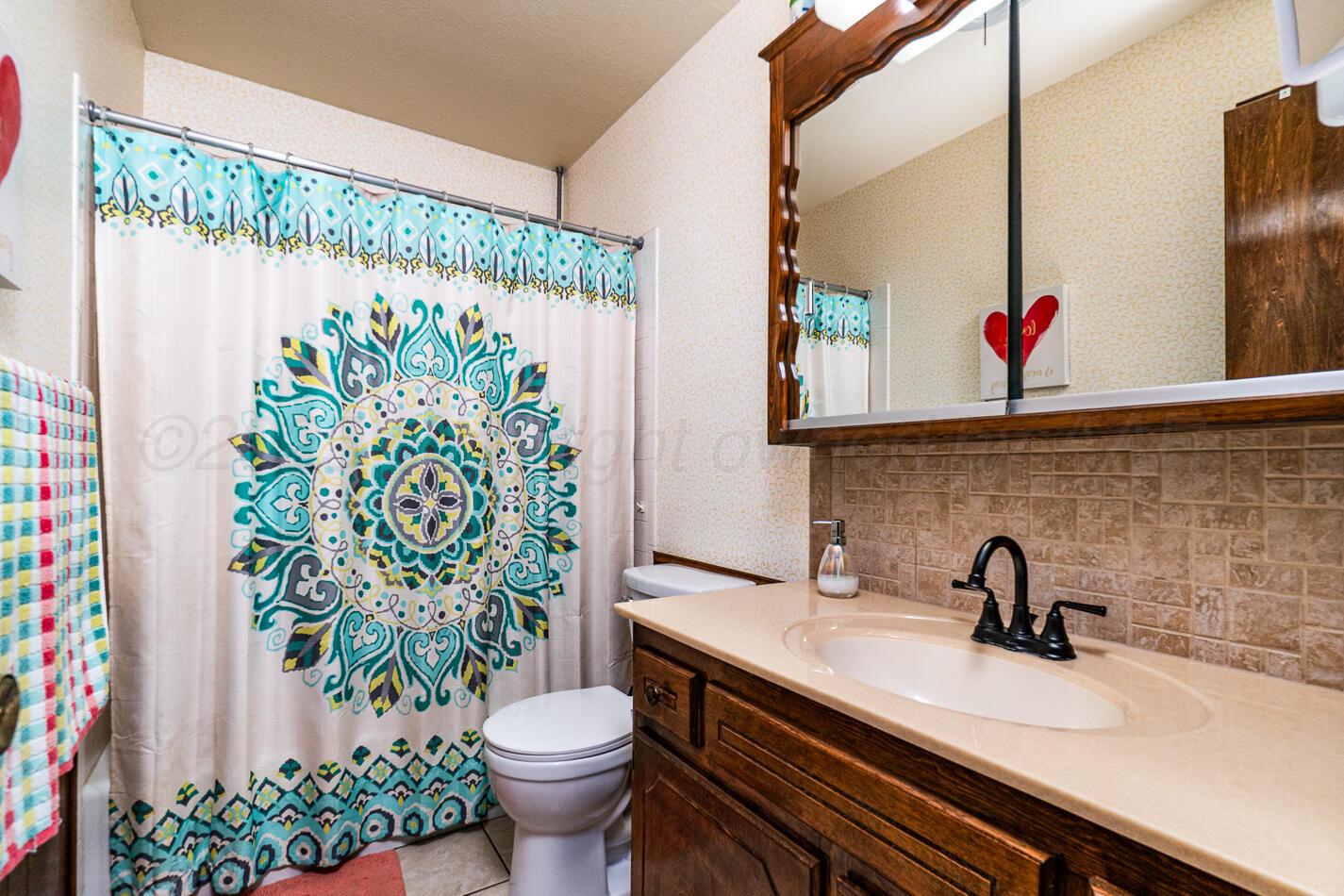 5702 South Milam Street Amarillo, TX 79110 - Photo 17 of 22 a bathroom with a sink and a mirror