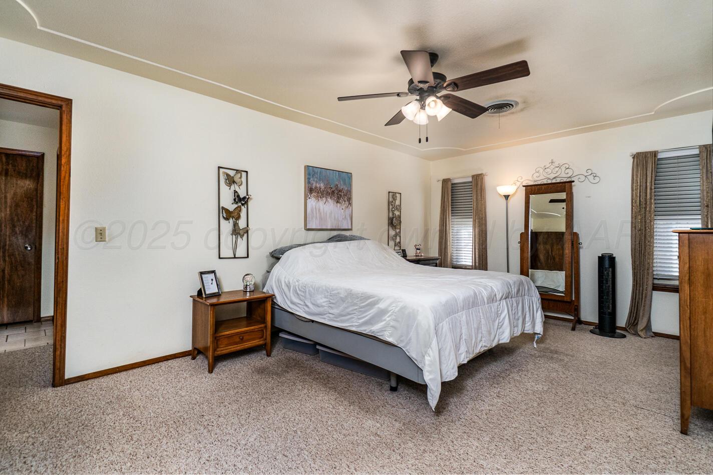 5702 South Milam Street Amarillo, TX 79110 - Photo 4 of 22 a spacious bedroom with a bed and a ceiling fan