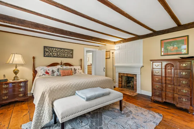 a bedroom with a bed a fireplace and furniture