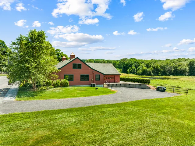 a view of a house with a big yard and a large tree