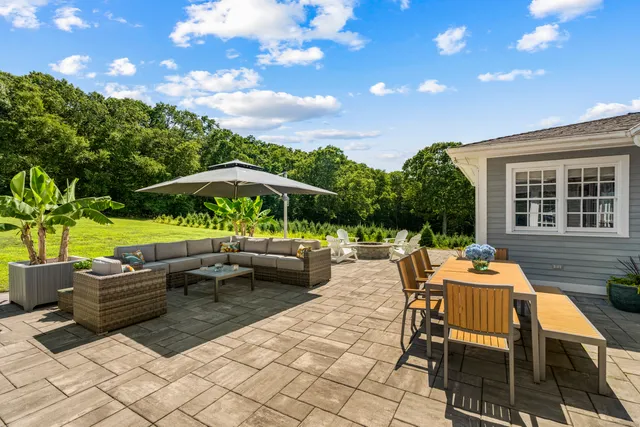 a backyard of a house with barbeque oven table and chairs