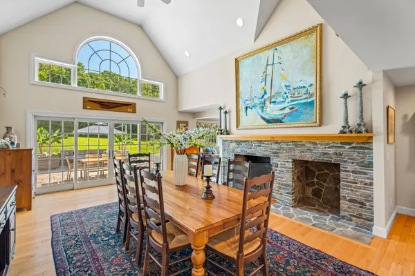a dining room with furniture a fireplace and a floor to ceiling window