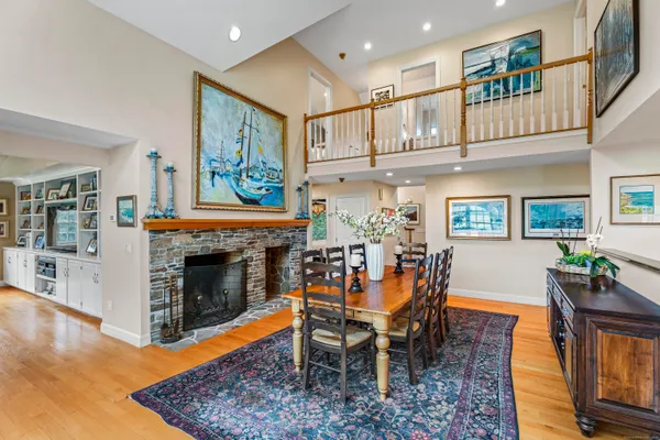 a dining room with furniture a fireplace and wooden floor