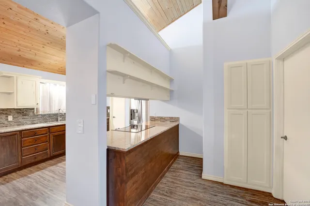 a large kitchen with a sink and dishwasher a stove with wooden floor