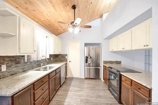 a kitchen with stainless steel appliances granite countertop a sink and a refrigerator