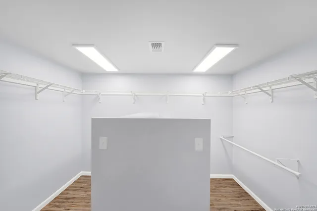 a view of walk in closet with empty racks