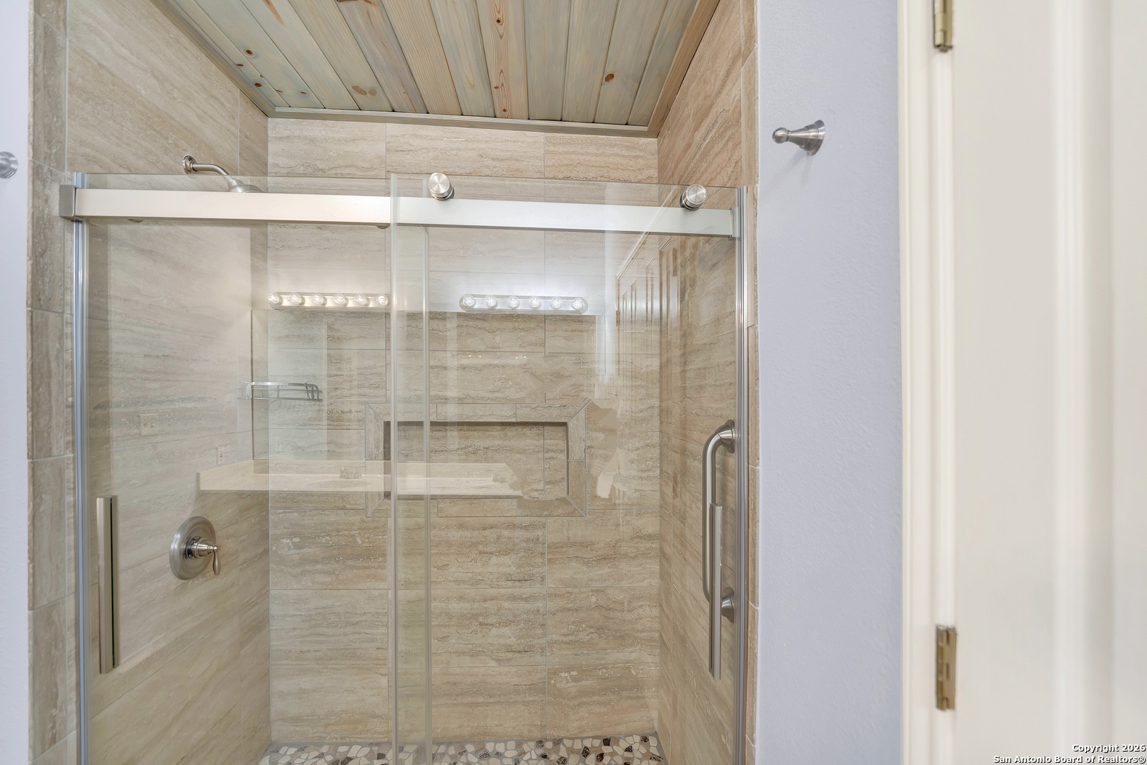 568 Firewheel Drive Bandera, TX 78003 - Photo 26 of 45 a bathroom with a glass shower door