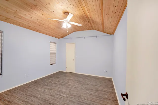 a view of an empty room with wooden floor