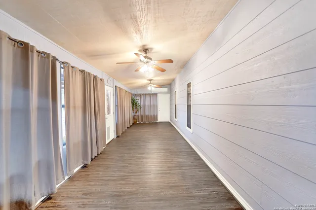 a view of a hallway with wooden floor