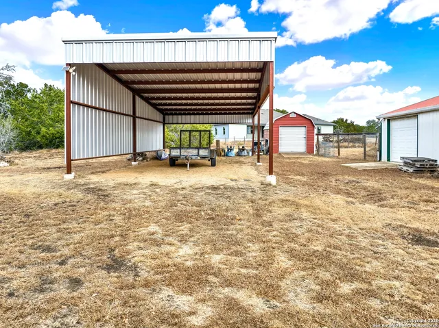 a view of a house with backyard and sitting area