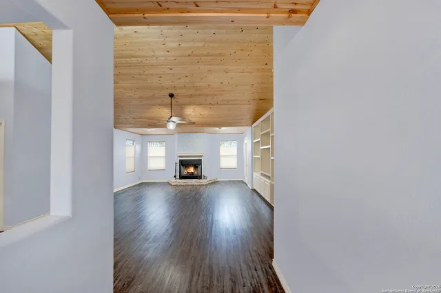 a view of empty room with wooden floor and fireplace