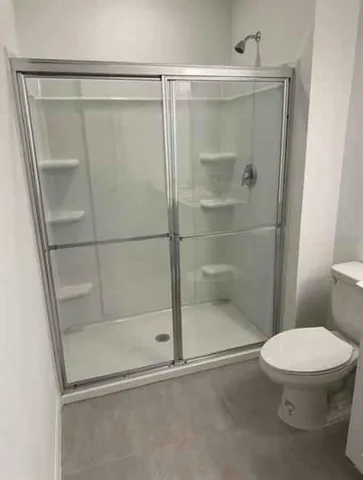 a bathroom with a shower a toilet and a sink