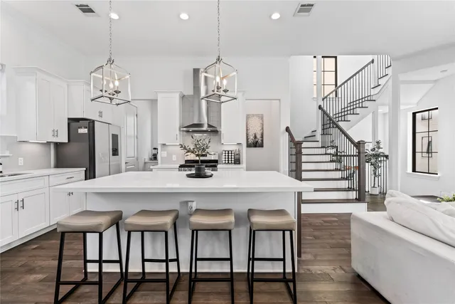 a kitchen with stainless steel appliances a table chairs and a chandelier