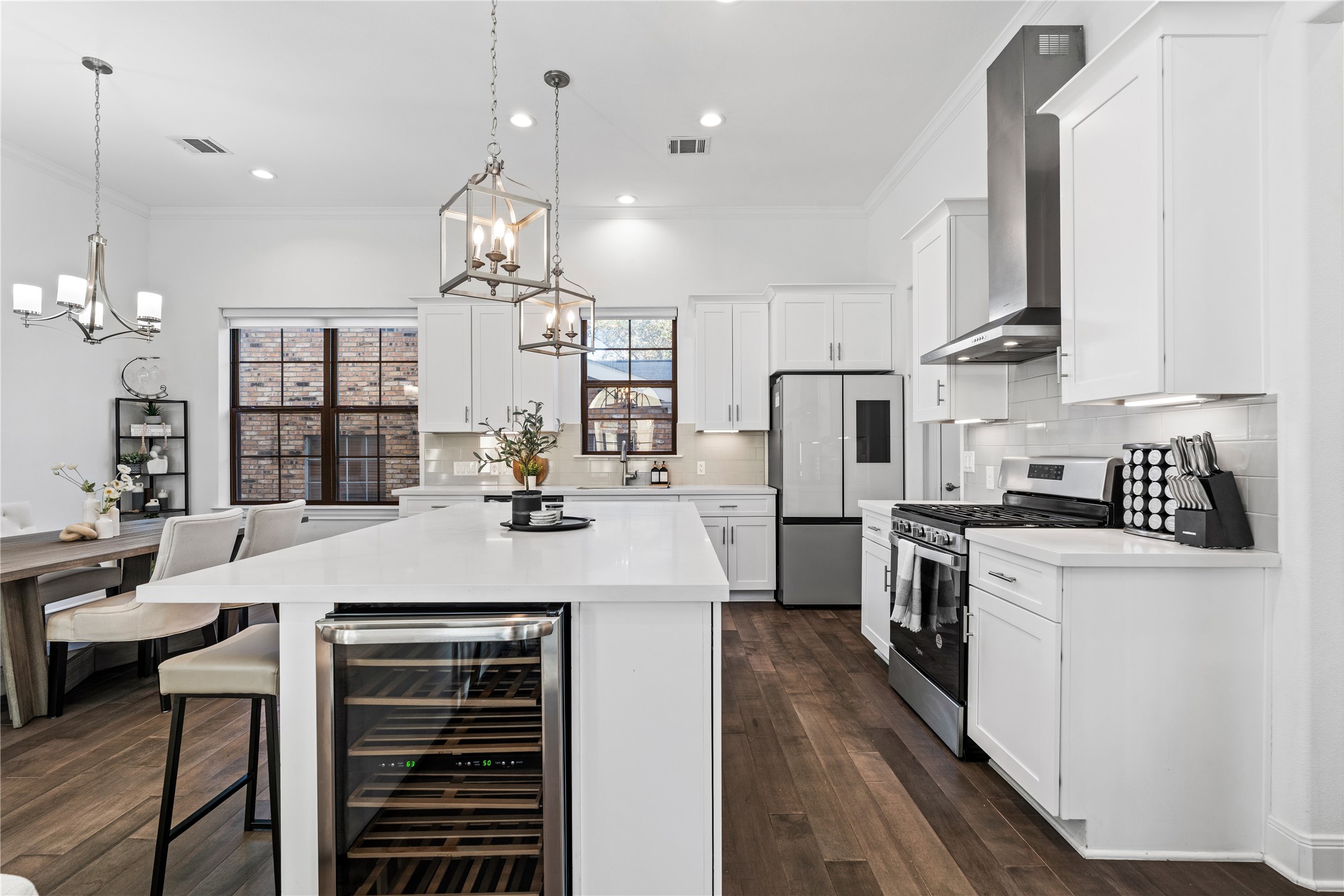 3319 Beverly Forest Drive Houston, TX 77057 - Photo 14 of 32 a large kitchen with kitchen island a stove a sink a refrigerator and a dining table with wooden floor