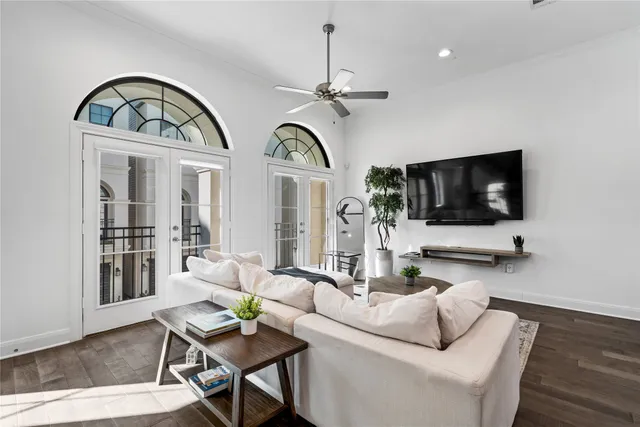 a living room with furniture a flat screen tv and a floor to ceiling window