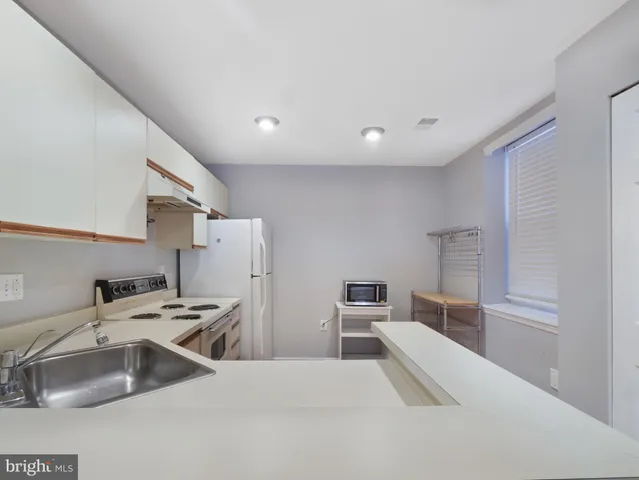 a kitchen with a sink a stove and cabinets