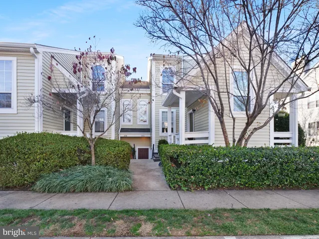 a front view of a house with lots of trees and plants