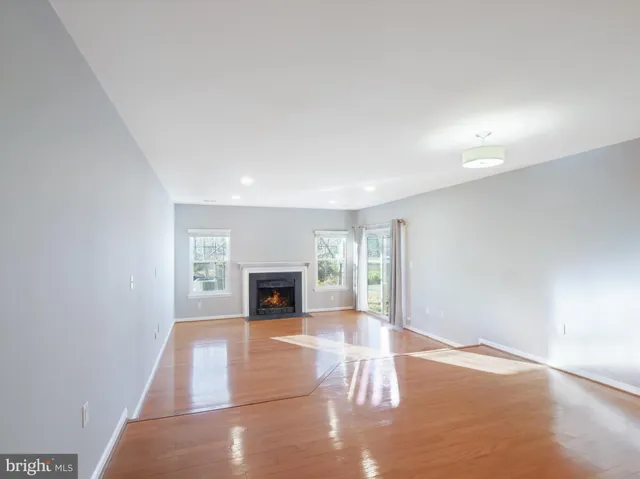 an empty room with floor to ceiling window and fireplace
