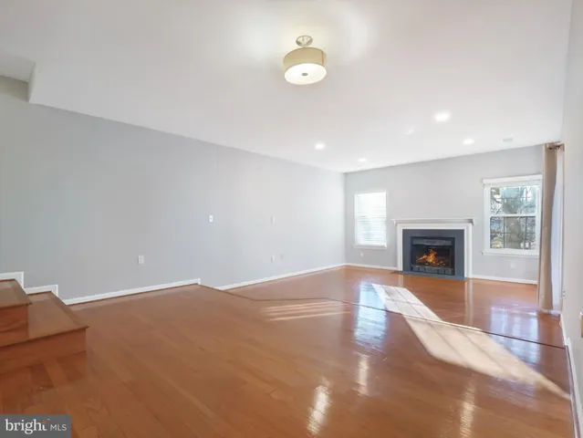 a view of an empty room with a fireplace and a window