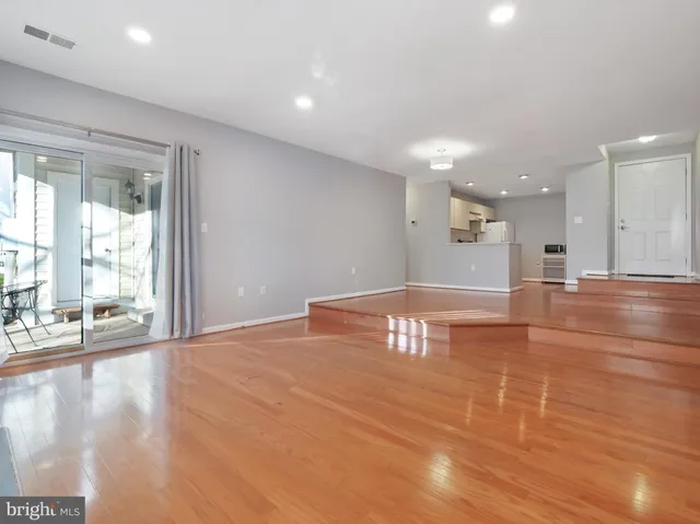 a view of an empty room with wooden floor