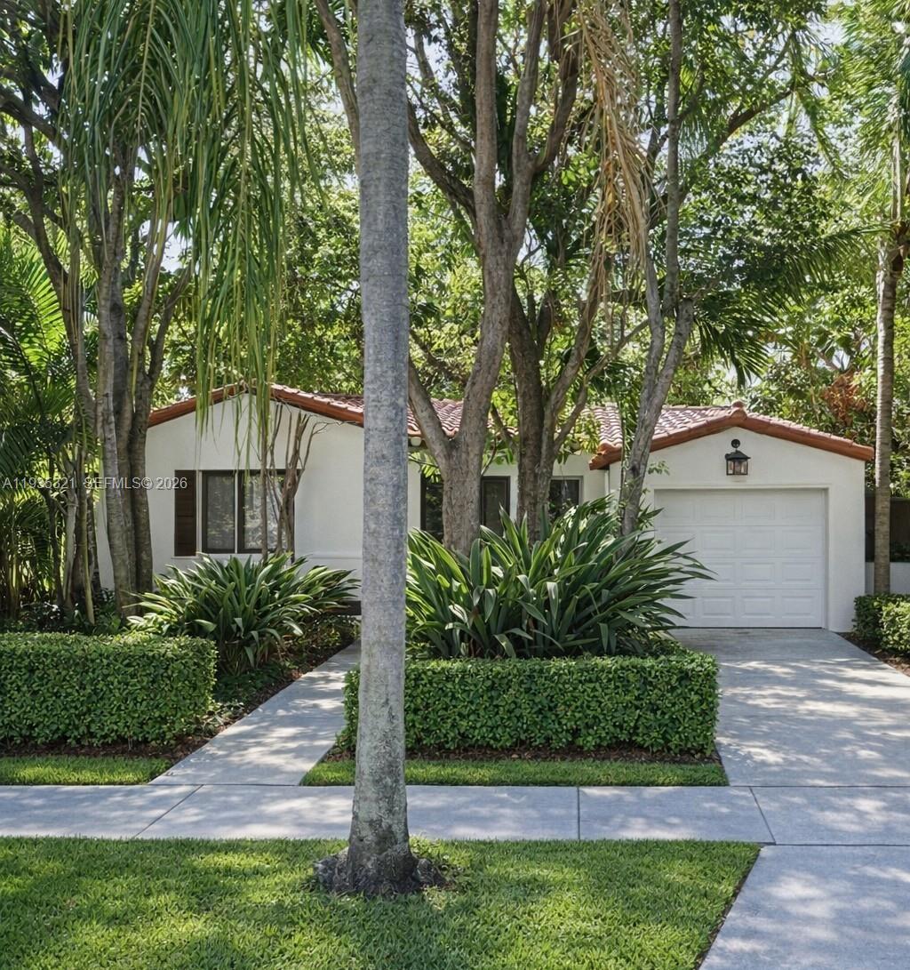 a front view of a house with a yard and potted plants