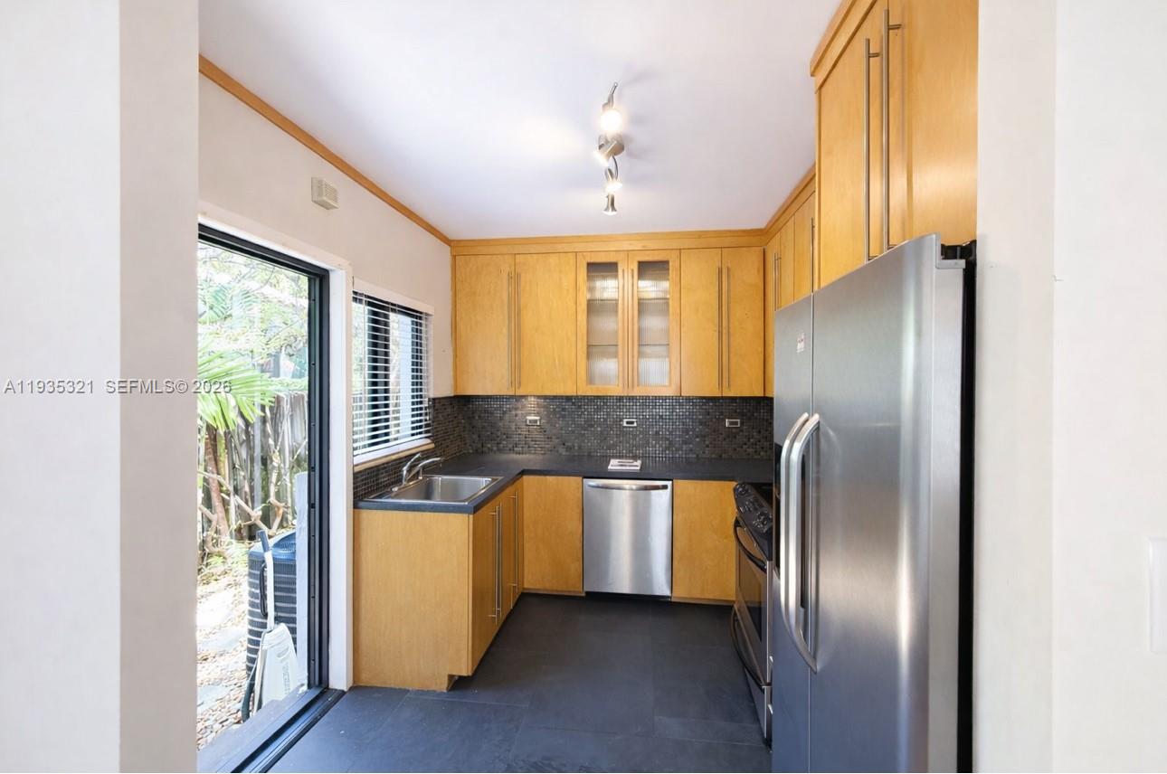 1780 Southwest 21st Street Miami, FL 33145 - Photo 11 of 17 a kitchen with stainless steel appliances granite countertop a refrigerator a sink and a stove