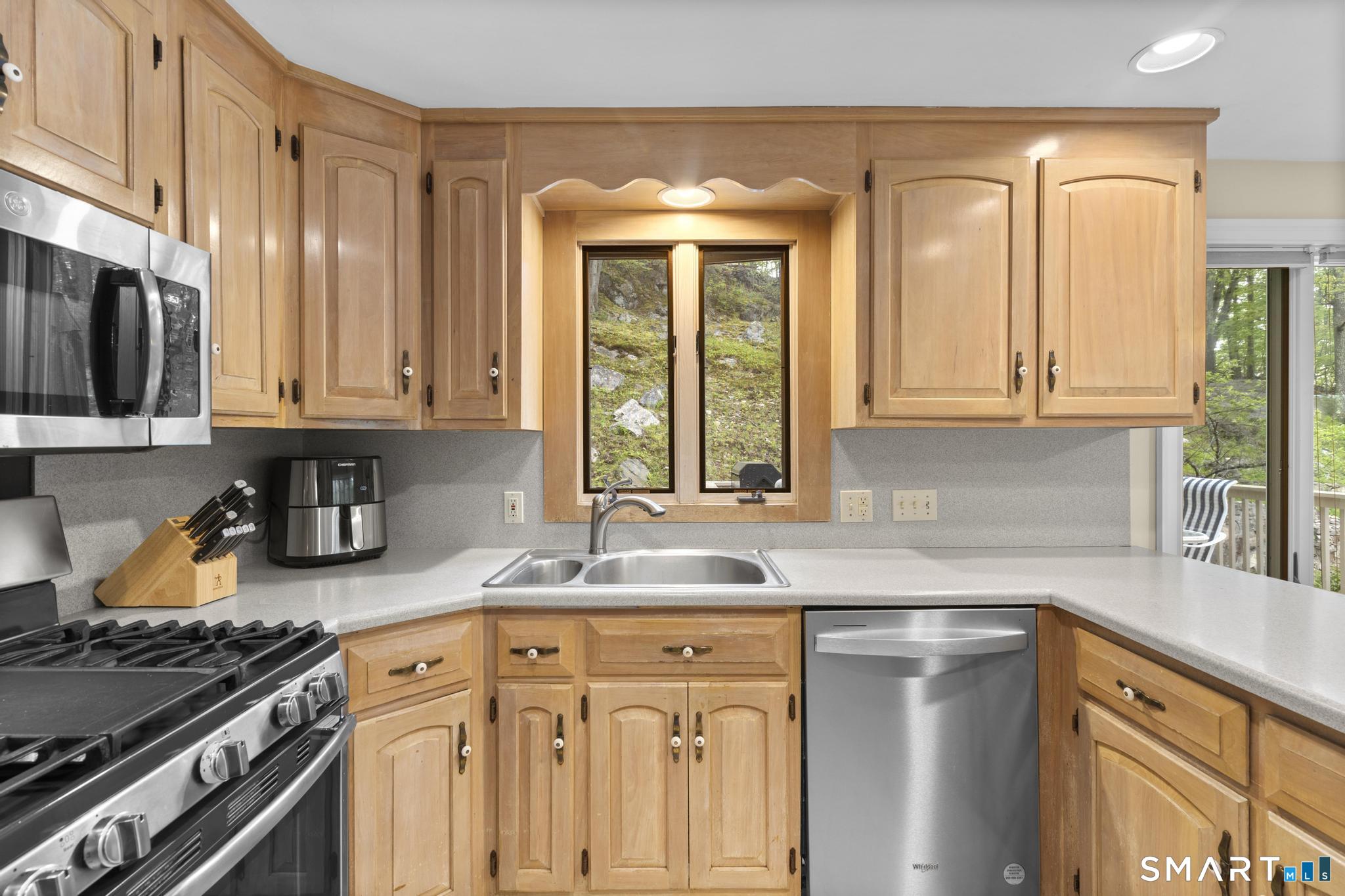 832 Quarter Mile Road Orange, CT 06477 - Photo 15 of 39 a kitchen with stainless steel appliances granite countertop a sink stove and cabinets