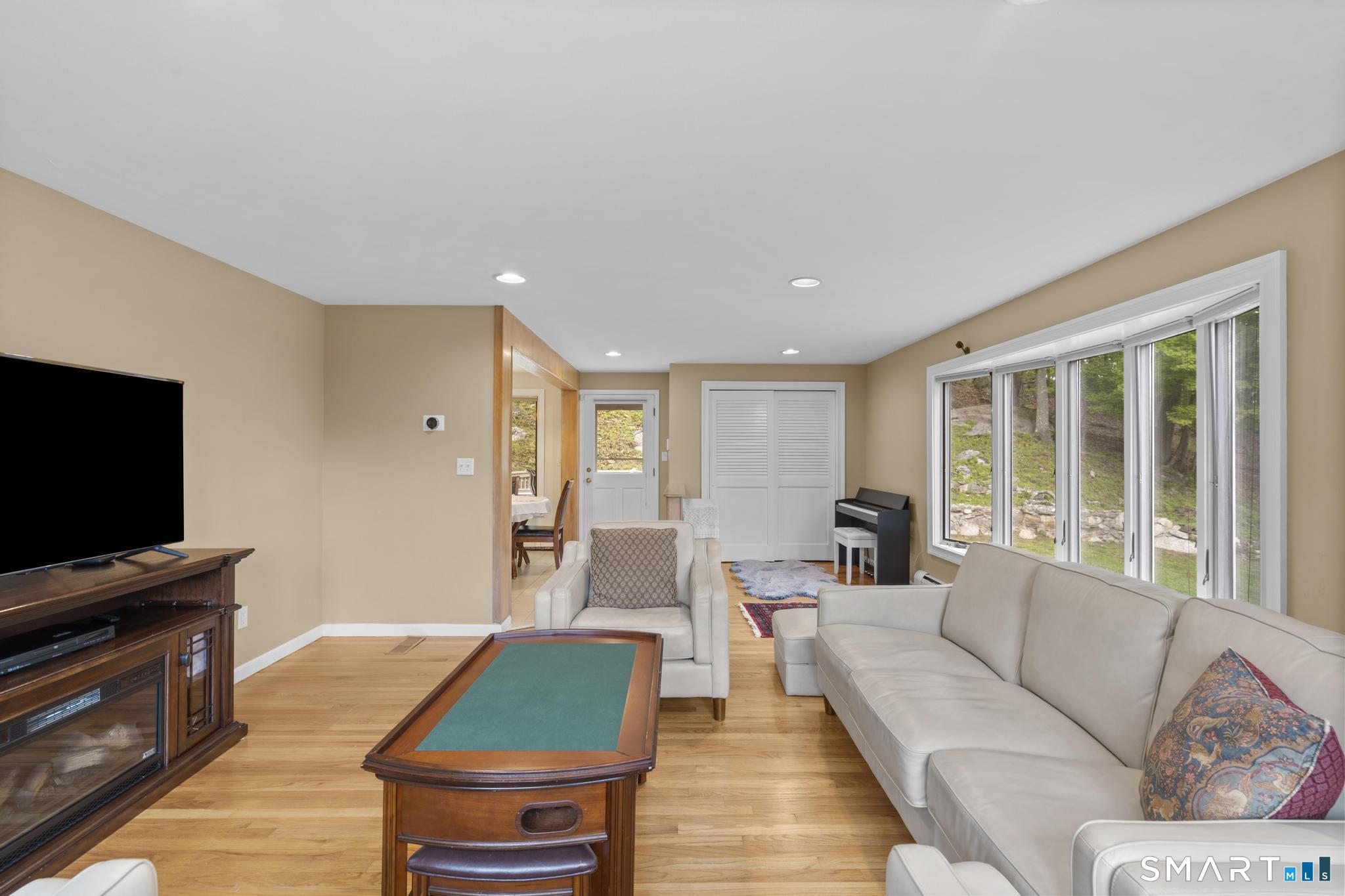 832 Quarter Mile Road Orange, CT 06477 - Photo 26 of 39 a living room with furniture and a flat screen tv