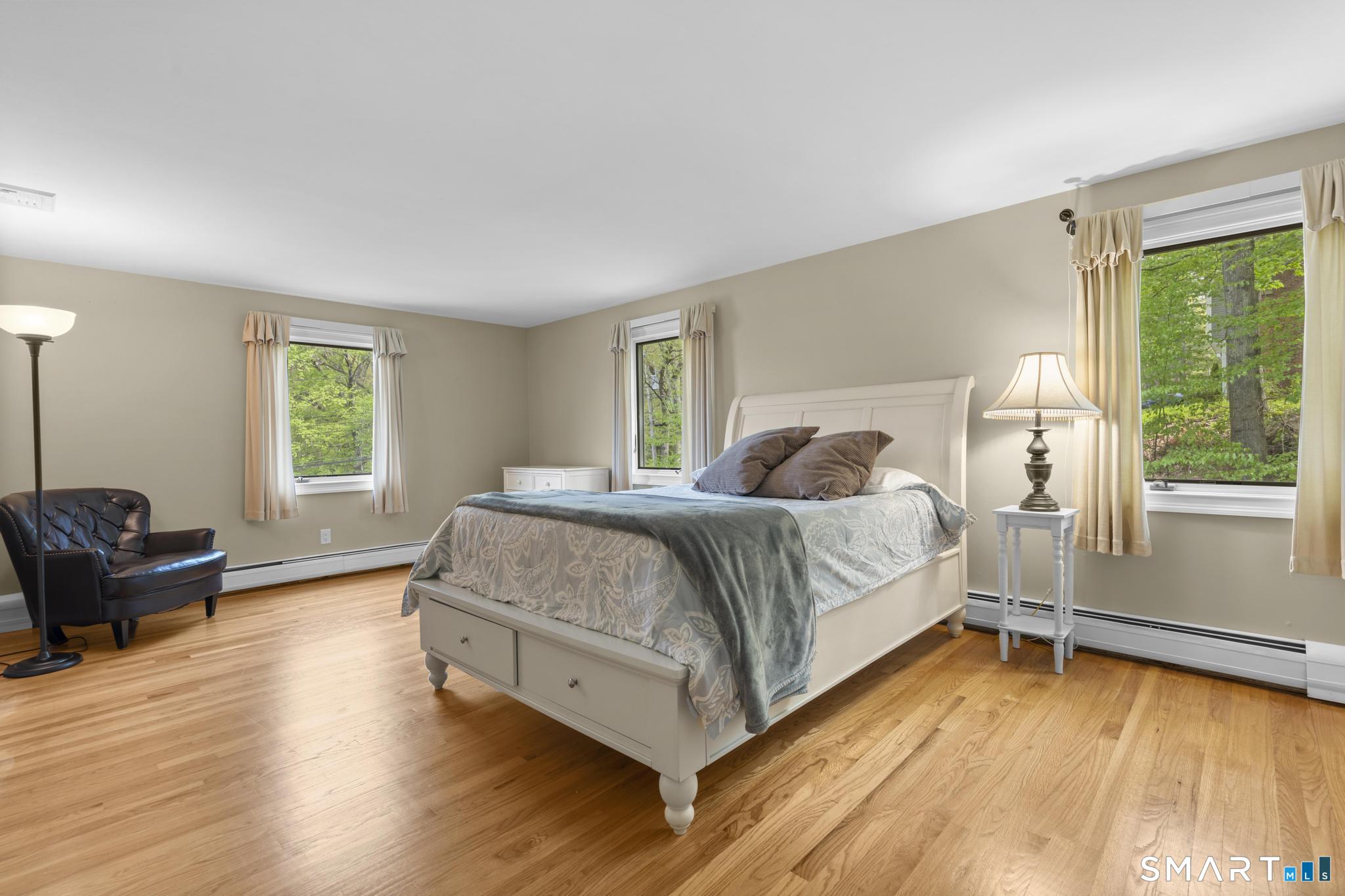 832 Quarter Mile Road Orange, CT 06477 - Photo 27 of 39 a bedroom with a bed and wooden floor