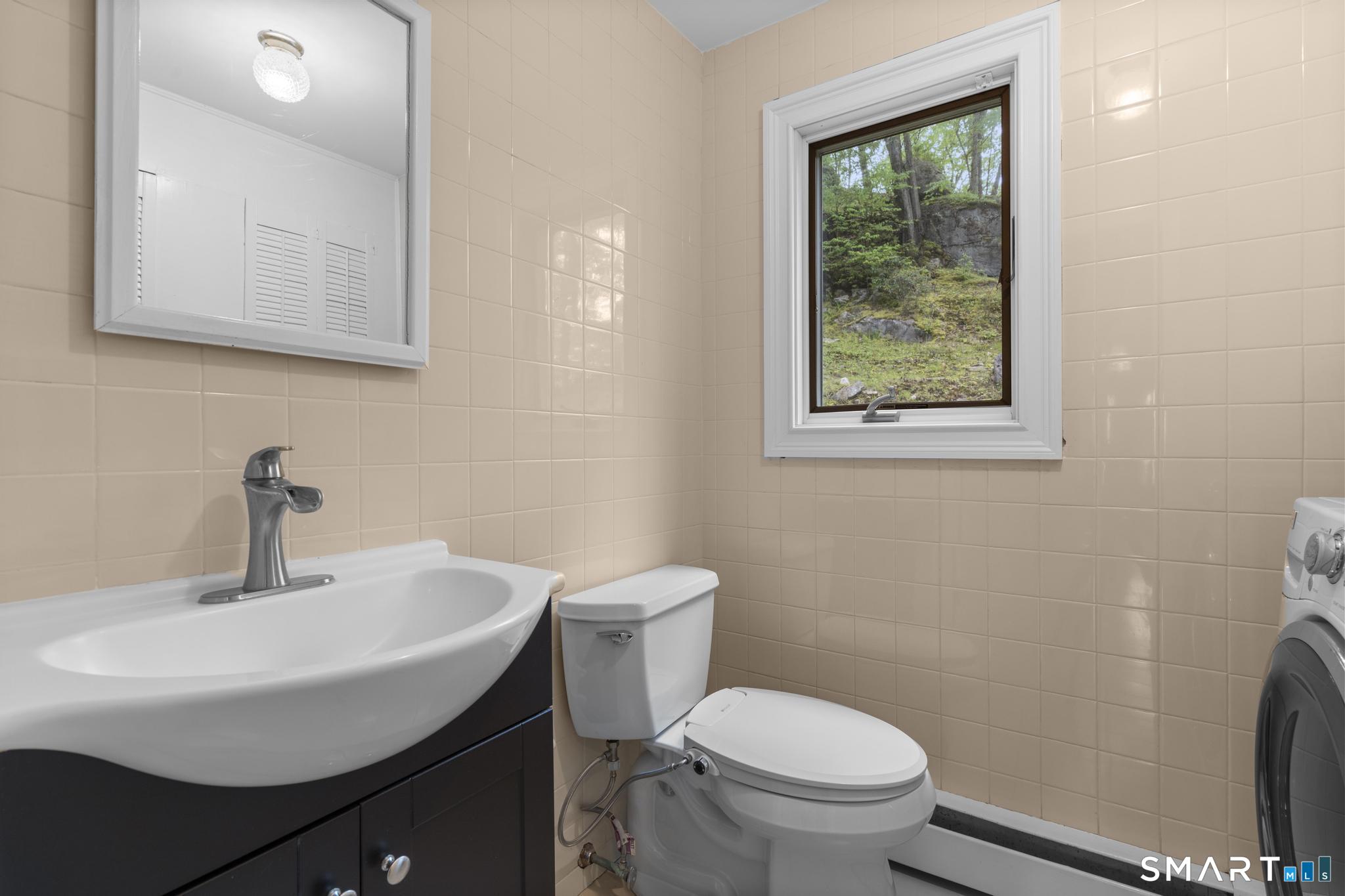 832 Quarter Mile Road Orange, CT 06477 - Photo 28 of 39 a bathroom with a sink a toilet and a mirror