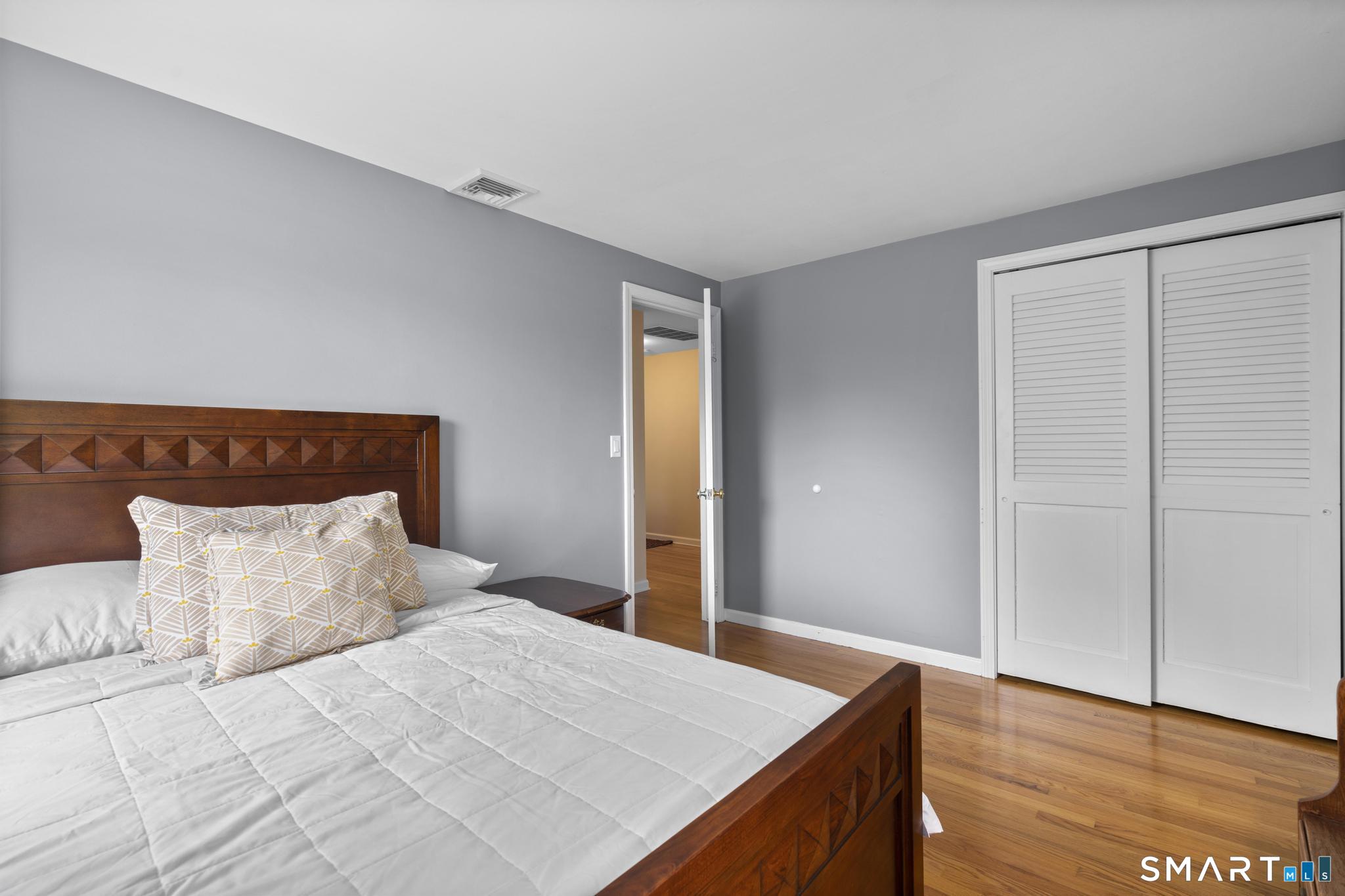 832 Quarter Mile Road Orange, CT 06477 - Photo 37 of 39 a bedroom with a bed and wooden floor