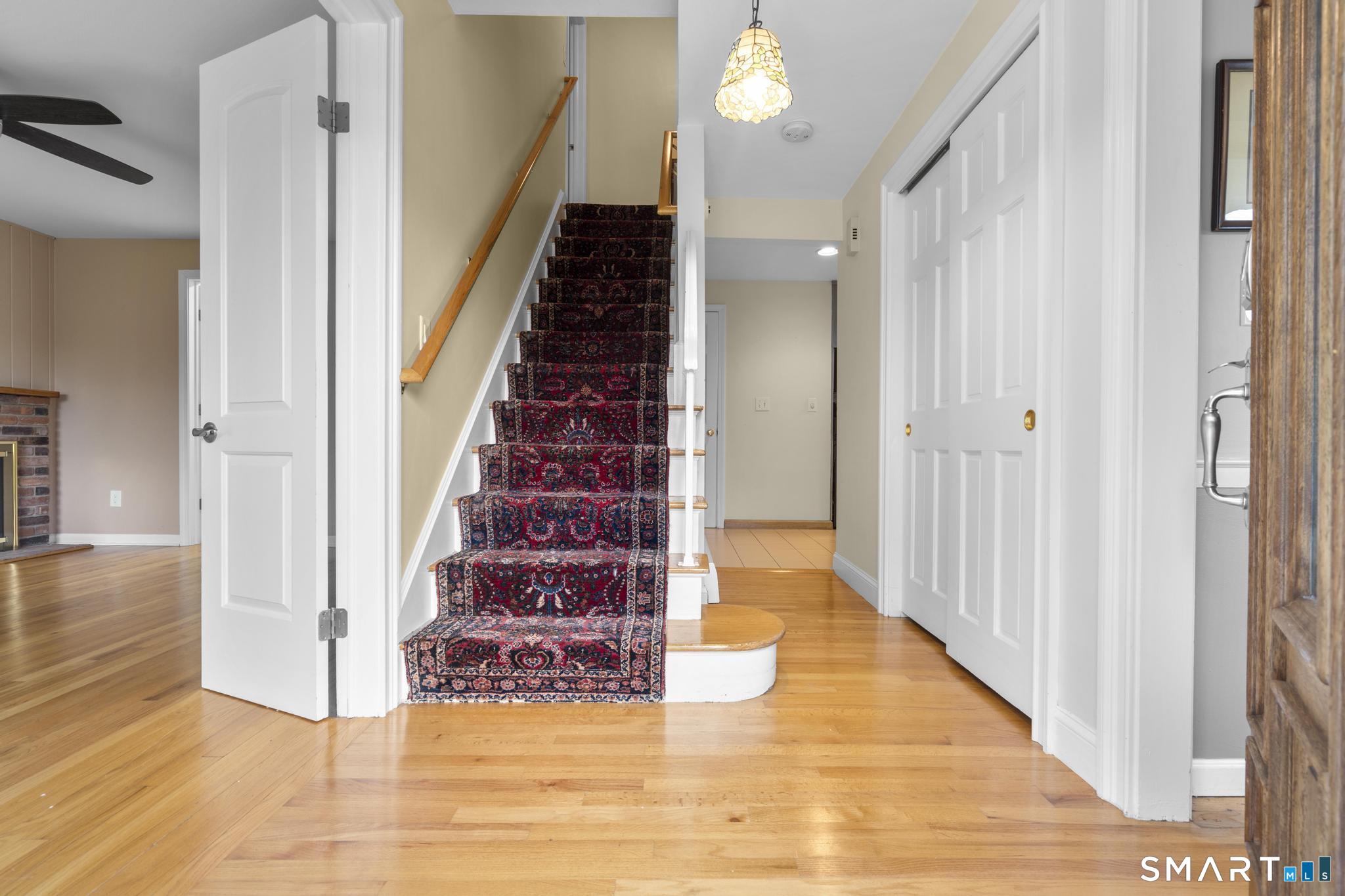 832 Quarter Mile Road Orange, CT 06477 - Photo 8 of 39 a view of a hallway with wooden floor and staircase