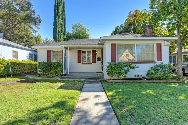 a view of a house with a yard and potted plants
