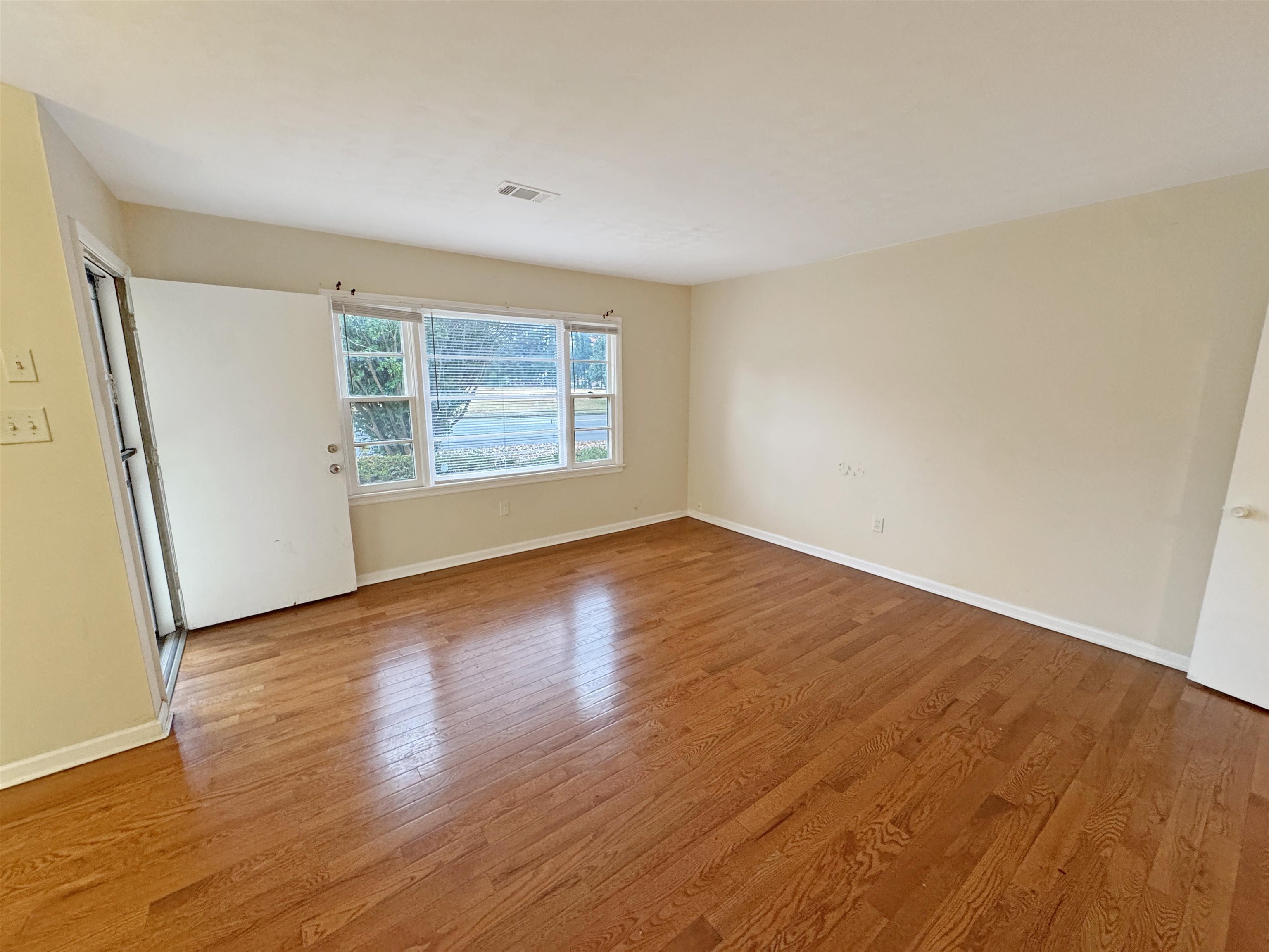 1519 South White Station Road Memphis, TN 38117 - Photo 2 of 31 an empty room with wooden floor and windows