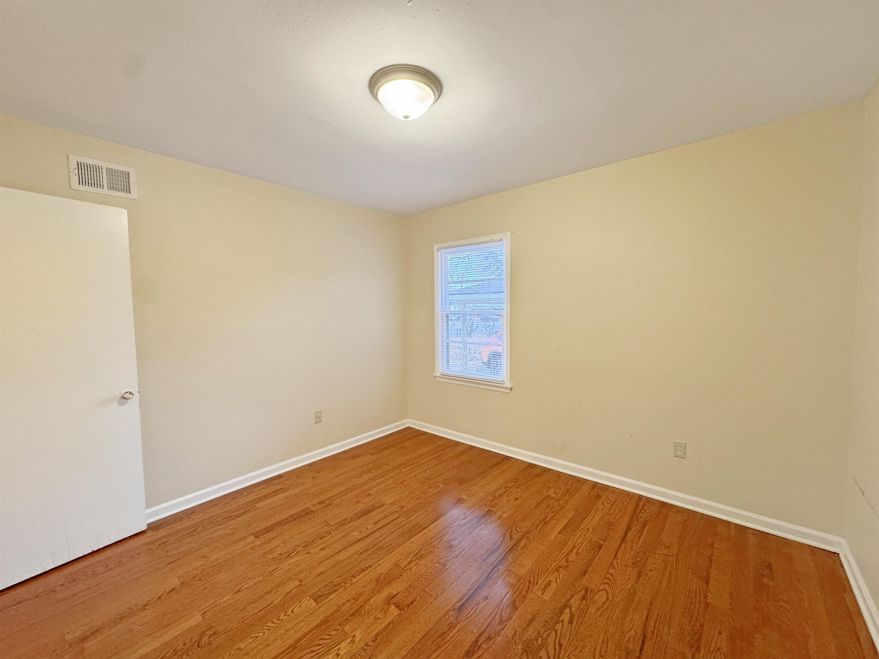 1519 South White Station Road Memphis, TN 38117 - Photo 8 of 31 an empty room with wooden floor and windows