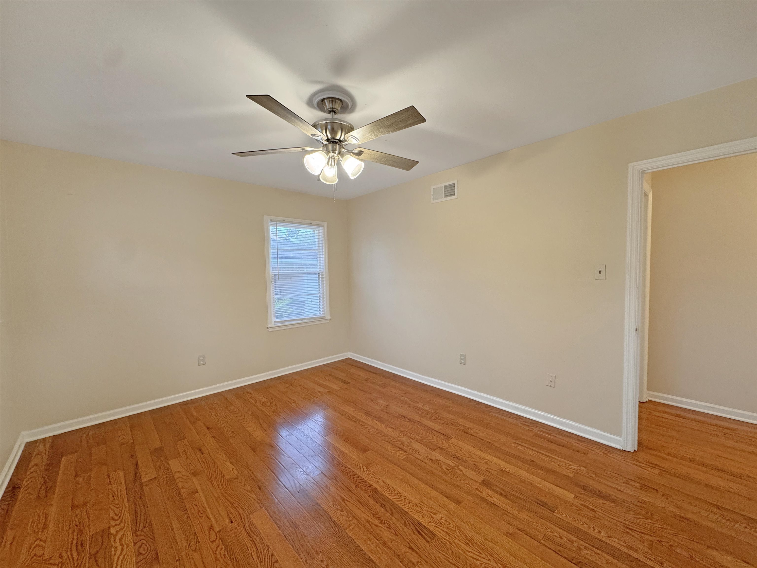 1519 South White Station Road Memphis, TN 38117 - Photo 9 of 31 an empty room with wooden floor and a ceiling fan